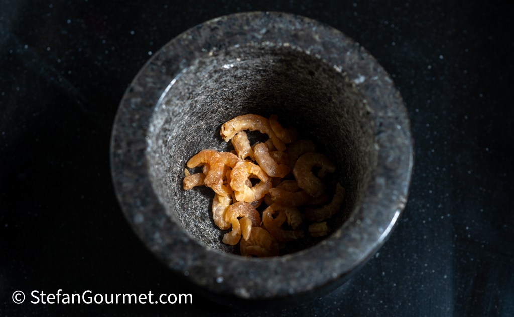 A mortar filled with dried shrimp, ready for preparation in Thai cooking.