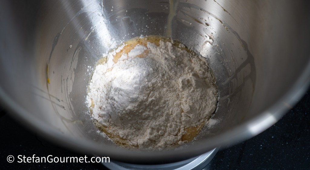 Ingredients for girini batter with flour and eggs in a mixing bowl.