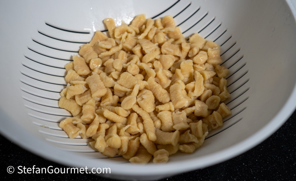 Freshly made girini pasta resting in a colander.
