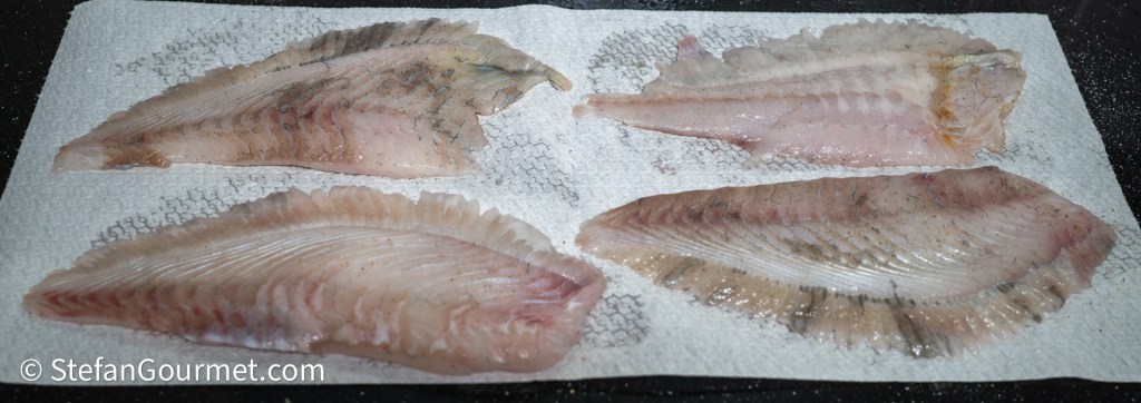 Four fillets of fish arranged on a paper towel, showing the fresh, clean appearance of the fish.