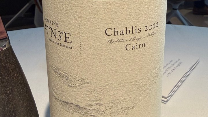Close-up of a wine bottle label featuring 'Chablis 2022 Cairn' with textured paper and elegant typography.