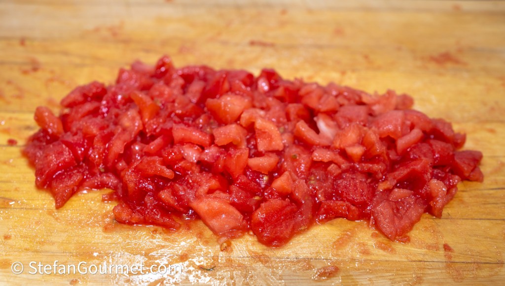 Chopped tomatoes on a wooden cutting board.